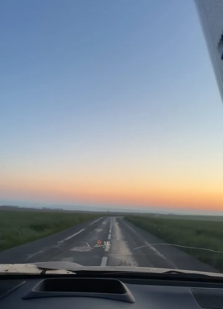 Route de campagne au lever du soleil, vue depuis le taxi