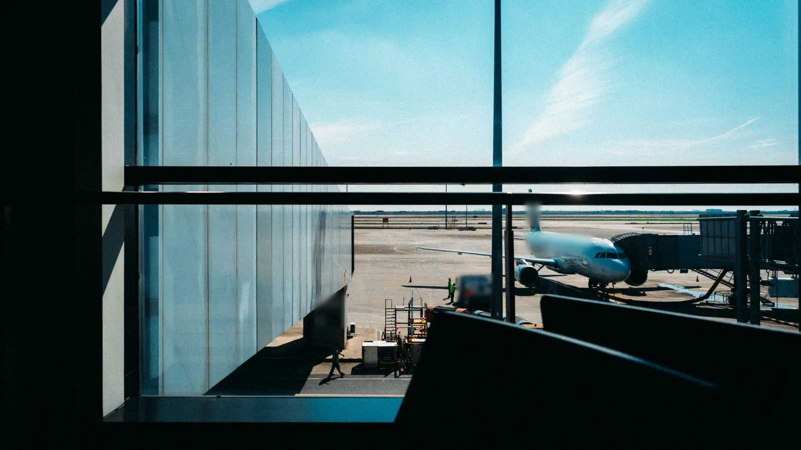 Avion à la passerelle vu depuis la baie vitrée d'un terminal