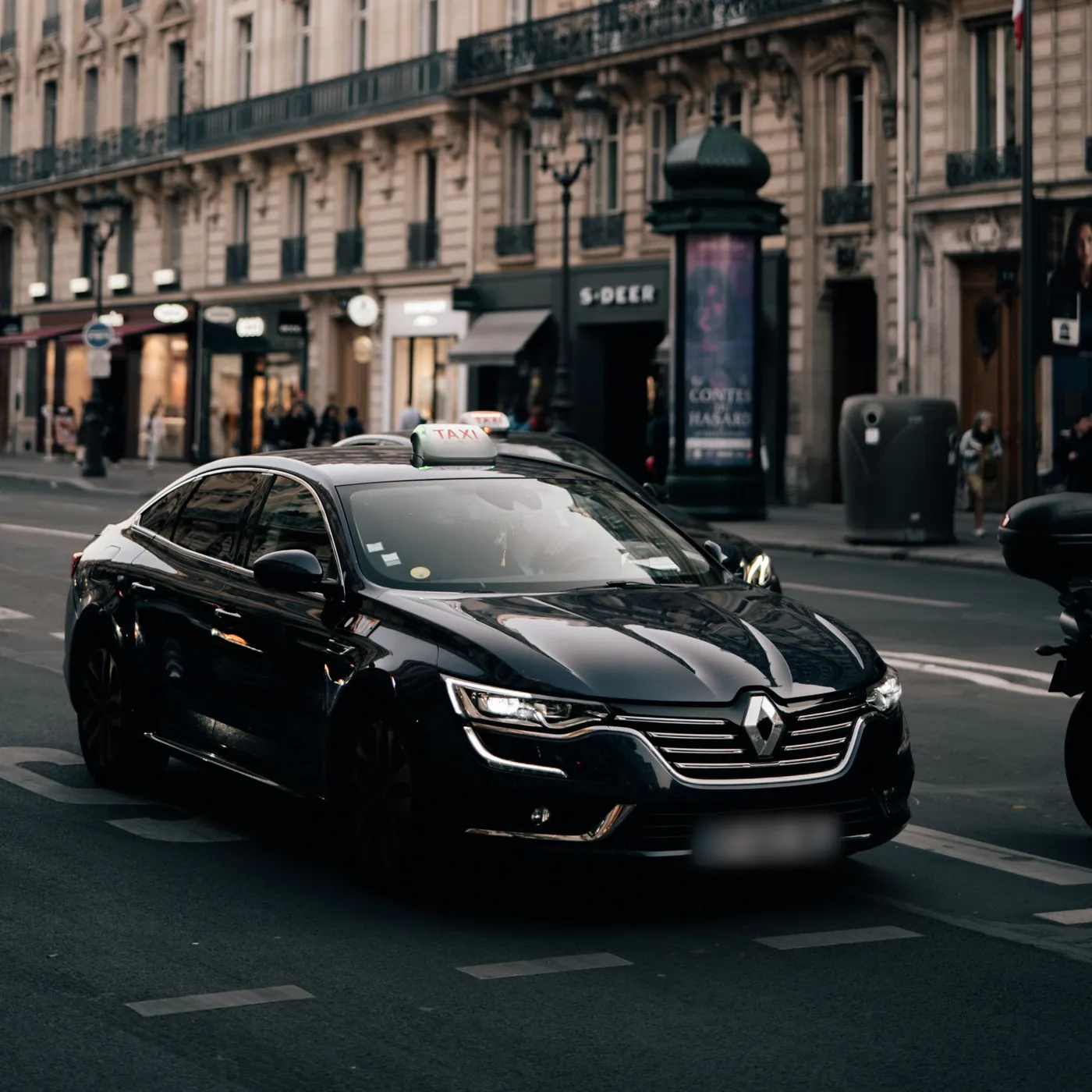 Taxi noir, lumineux TAXI sur le toit, dans une rue parisienne